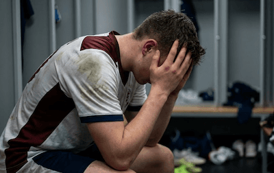 A person losing a game — head in hands