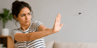 A woman waving her hand to shoo away an insect
