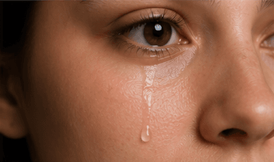 A teardrop falling from an eye while crying